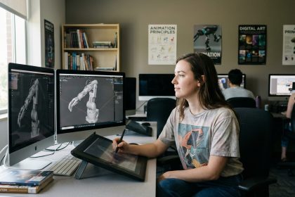 Jeune femme en atelier numérique utilisant une tablette graphique